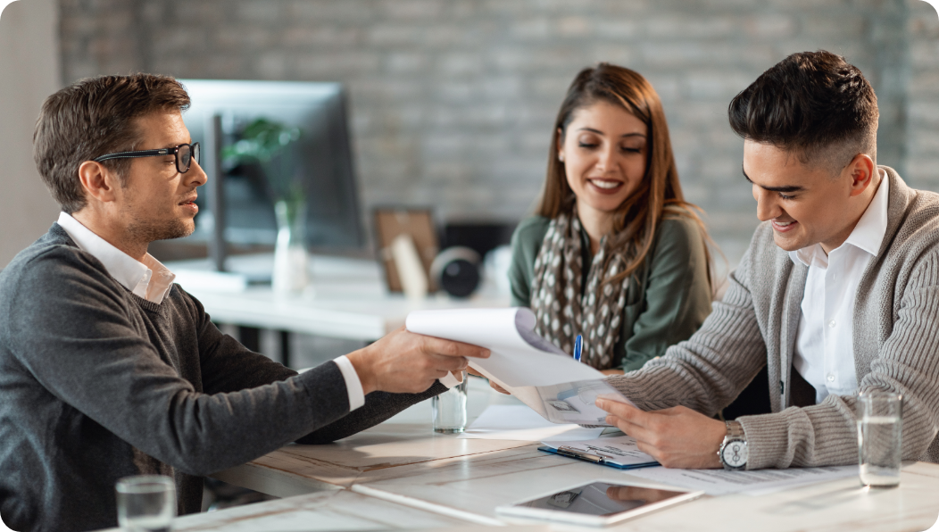 happy-couple-signing-contract-meeting-with-their-real-estate-agent-office